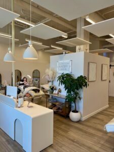 View of LashLuv Beauty Bar in Bothell WA showing the reception area, treatment beds, and esthetician performing a service – serving Mill Creek, Kenmore, and Woodinville clients