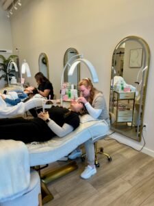Two estheticians shaping and tinting brows and lashes inside LashLuv Beauty Bar’s Bothell WA studio – proudly serving clients from Kenmore, Mill Creek, and Woodinville