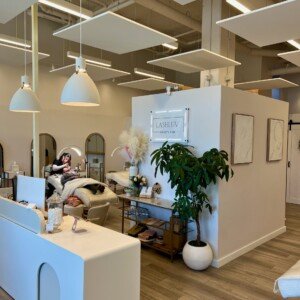 View of LashLuv Beauty Bar in Bothell WA showing the reception area, treatment beds, and esthetician performing a service – serving Mill Creek, Kenmore, and Woodinville clients