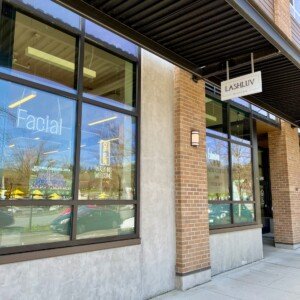 Exterior view of LashLuv Beauty Bar storefront on sidewalk level below apartments in Bothell WA β welcoming clients from Mill Creek, Kenmore, and Woodinville